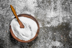 Bowl of baking soda with spoon to remove a hair clog