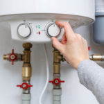 Person putting hand on water heater