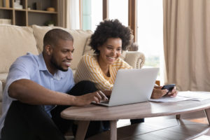 Young couple on couch viewing top plumbing trends in 2023