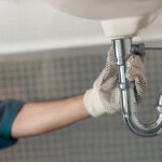 Close up of male plumber repairing faucet at bathroom plumbing services in anaheim