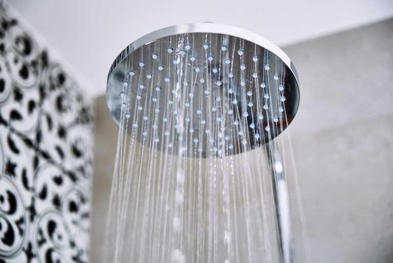 water flowing from shower head in bathroom scaled